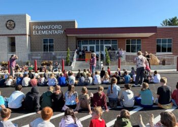Students sat on the pavement looking at the remodeled school in the background (Photo: Brandon Baker)